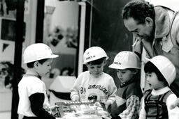 Daycare children examine Cedar building pans