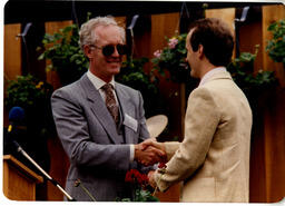 Two men shaking hands at graduation